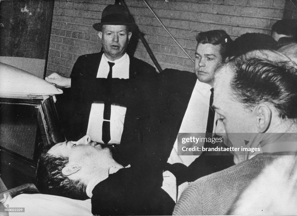 The Alleged Assassin Lee Harvey Oswald Is Being Removed On Strecher After Being Shot By The Nightclub Operator Jack Ruby Two Days After He Had Murdered President John F. Kennedy. Dallas. Texas. 24Th November 1963. Photograph.