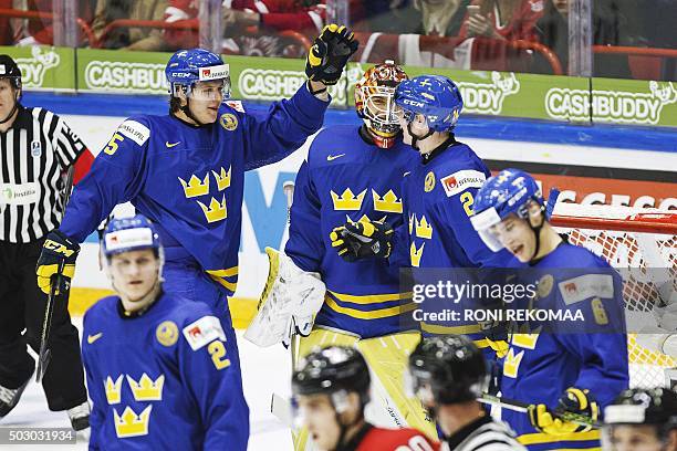 Sweden's Anton Karlsson, Adam Ollas Mattsson, goalie Felix Sandstrom, Jens Looke and Andreas Englund celebrate after beating Canada 2-5 during the...