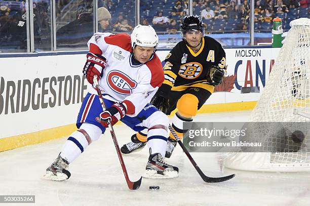 Oleg Petrov of the Montreal Canadiens skates against Don Sweeney of the Boston Bruins during the alumni game December 31, 2015 during 2016...