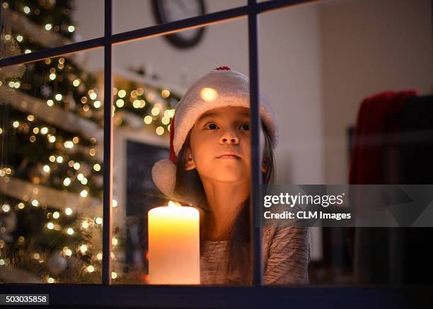 little girl looking out the window on christmas - children christmas ストックフォトと画像
