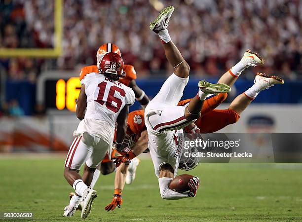 Sterling Shepard of the Oklahoma Sooners is upended by T.J. Green of the Clemson Tigers in the fourth quarter during the 2015 Capital One Orange Bowl...