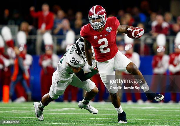 Running back Derrick Henry of the Alabama Crimson Tide runs the ball ahead of cornerback Arjen Colquhoun of the Michigan State Spartans in the second...