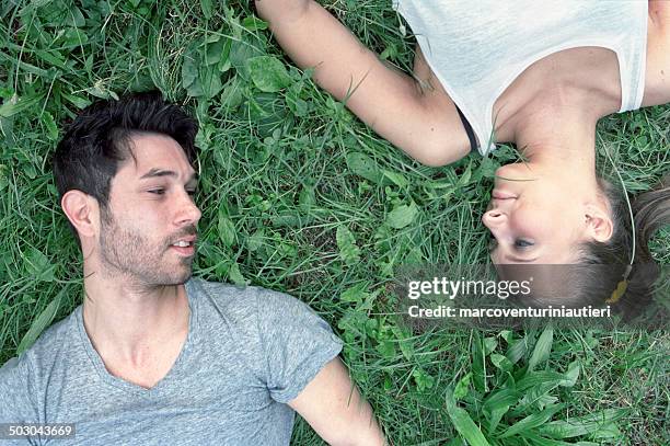 pareja, caer en el césped, mirando en cada - compassionate eye fotografías e imágenes de stock