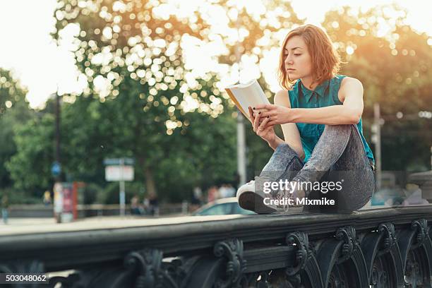 teenage girl reading a book - roman bridge stockfoto's en -beelden