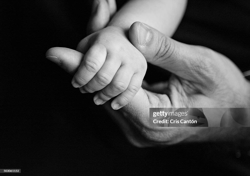 Baby holding father's hand