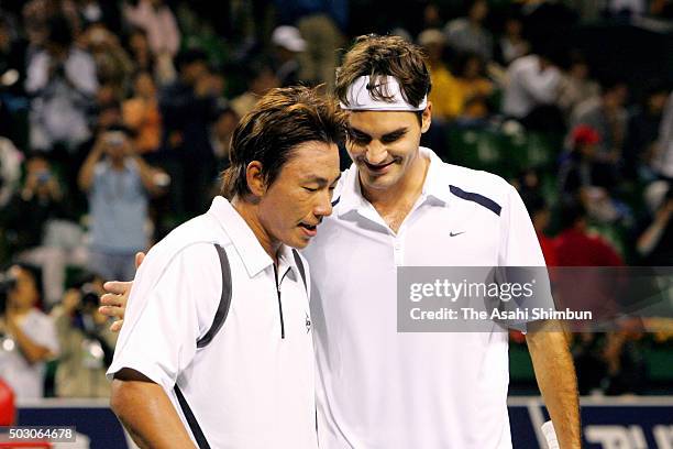 Roger Federer of Switzerland talks with Takao Suzuki of Japan after their men's singles quarter-final during day three of the AIG Open tennis at...