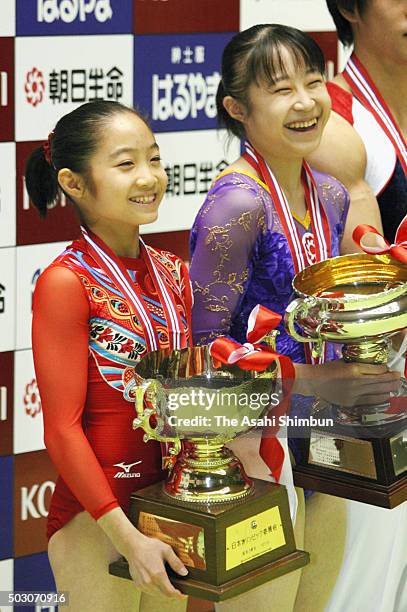 Gold medalist Koko Tsurumi and silver medalist Miki Uemura smile on the podium at the medal ceremony for the Women's All-Around during day two of the...