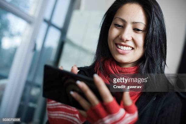 attraktive, junge, glückliche asiatische frau mit smartphone oder phablet. - formal glove stock-fotos und bilder