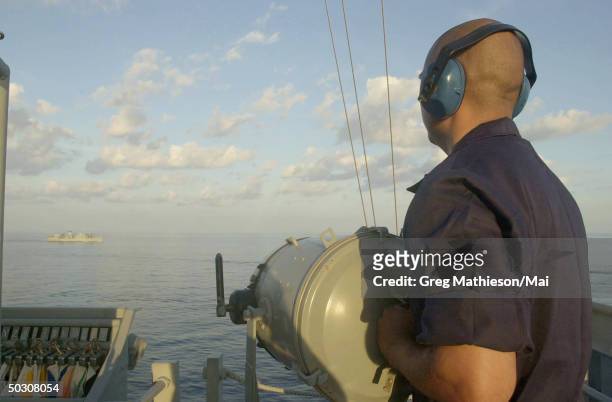 Signalman 2nd Class flashing morse code to the USS Bridge during a replenishment at sea with the USS Peleliu . The USS Peleliu is the flagship of an...