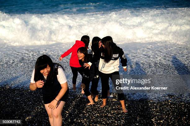 Tourists from mainland China giggle at Chishingtan Beach on January 1, 2016 in Hualien, Taiwan. The city of Hualien is the county seat of Hualien...