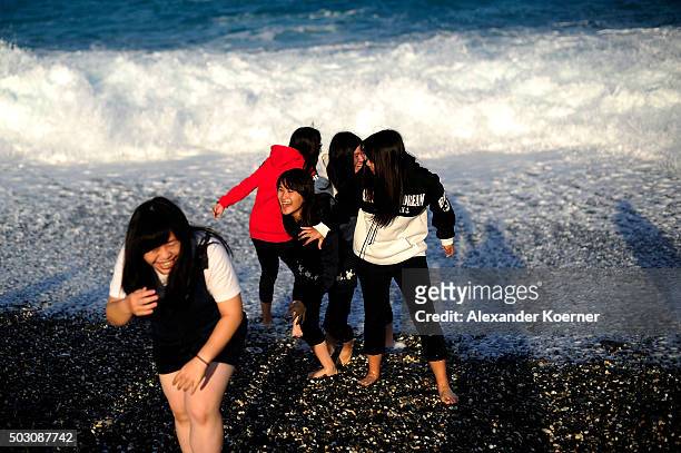 Tourists from mainland China giggle at Chishingtan Beach on January 1, 2016 in Hualien, Taiwan. The city of Hualien is the county seat of Hualien...