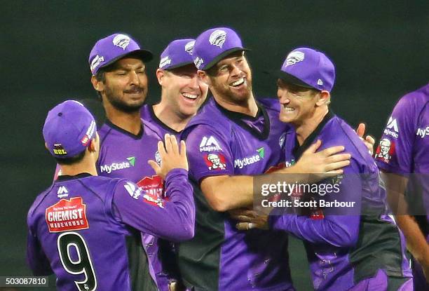 Dan Christian of the Hurricanes celebrates with Kumar Sangakkara and George Bailey after running out Chris Hartley of the Thunder during the Big Bash...