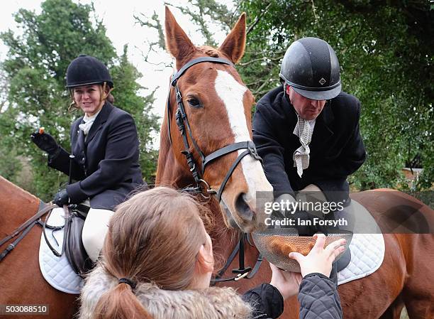 Rider takes a chicken nugget from a bowl as horses, riders and hounds from the Cleveland Hunt prepare to ride out on the traditional New Year's Day...