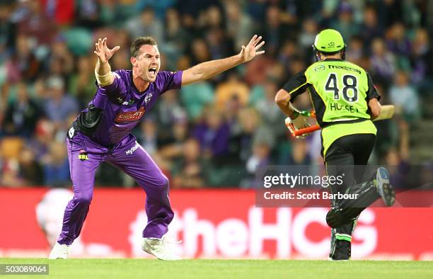 Shaun Tait of the Hurricanes appeals unsuccessfully as Mike Hussey of the Thunder runs between the wickets during the Big Bash League match between...