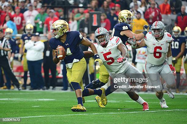 Quarterback DeShone Kizer of the Notre Dame Fighting Irish slips past linebacker Raekwon McMillan of the Ohio State Buckeyes during the first quarter...