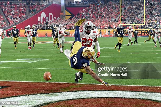 Tight end Alize Jones of the Notre Dame Fighting Irish can't haul in a pass while being defended by safety Tyvis Powell of the Ohio State Buckeyes...
