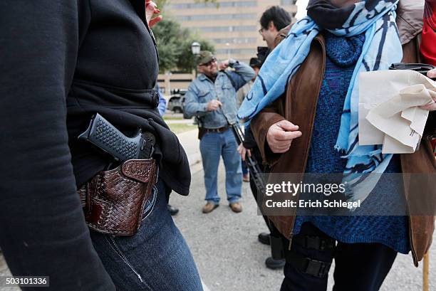 Two women compare handgun holsters during an open carry rally at the Texas State Capitol in Austin, Texas. On January 1 the open carry law took...