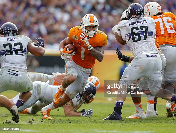 Jalen Hurd of the Tennessee Volunteers runs between Nate Hall and Tyler Lancaster of the Northwestern Wildcats during the second half of the Outback...