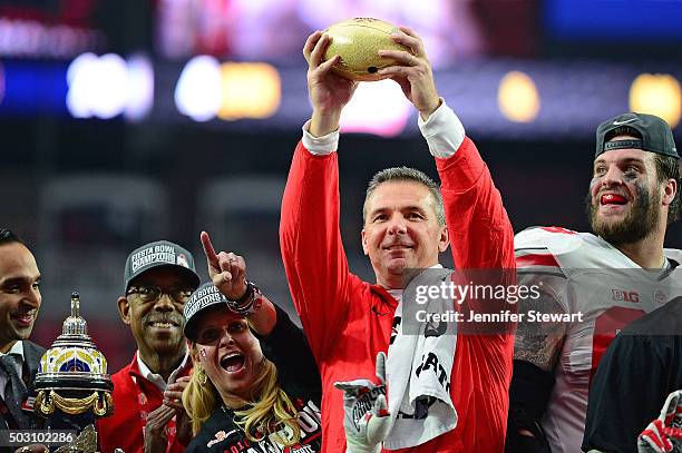 Head coach Urban Meyer of the Ohio State Buckeyes holds the Fiesta Bowl trophy after the BattleFrog Fiesta Bowl at University of Phoenix Stadium on...