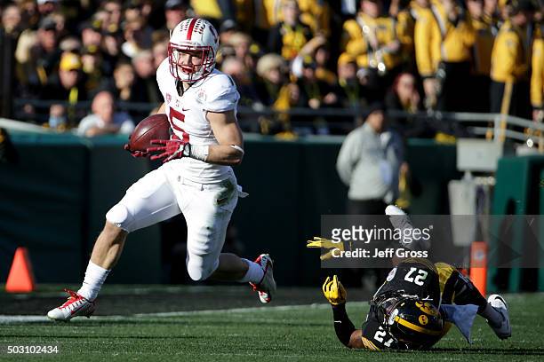 Christian McCaffrey of the Stanford Cardinal runs past Jordan Lomax of the Iowa Hawkeyes in the first quarter of the 102nd Rose Bowl Game on January...