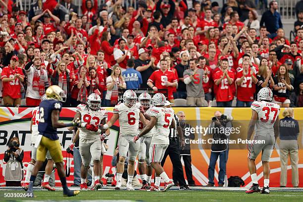 Defensive end Sam Hubbard of the Ohio State Buckeyes celebrates with Raekwon McMillan after a sack on quarterback DeShone Kizer of the Notre Dame...