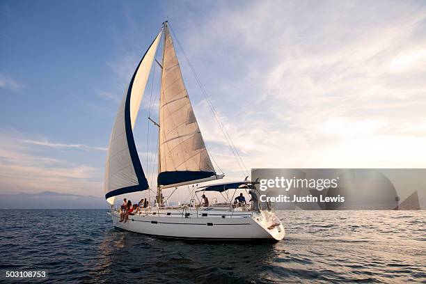 sunset on the open ocean w/beautiful sailboat - yacht photos et images de collection