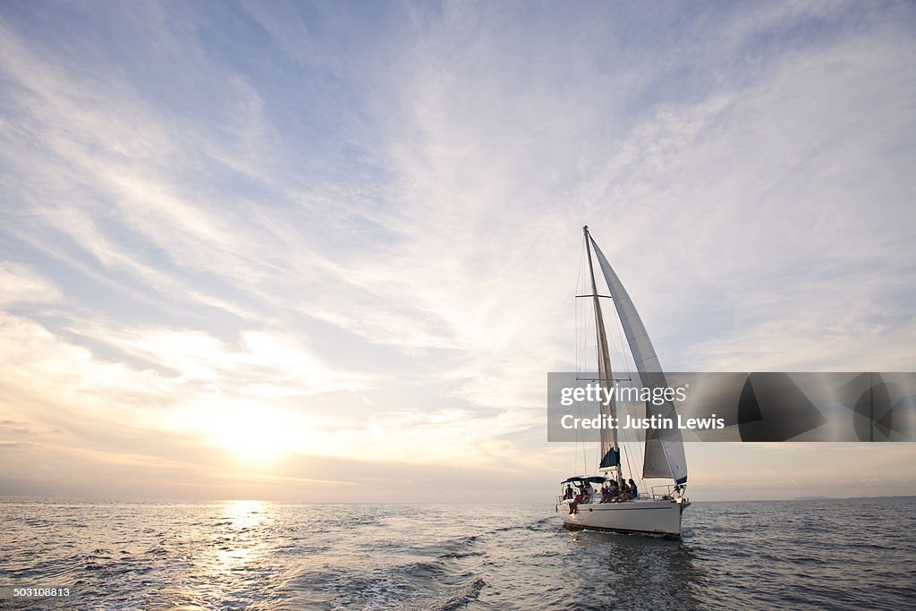 Sailboat cruise during gorgeous sunset at sea