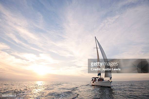 sailboat cruise during gorgeous sunset at sea - mezzo di trasporto marittimo foto e immagini stock
