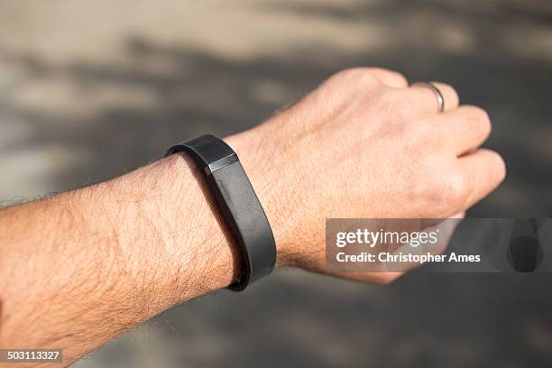 wearing a fitbit flex activity tracker - fitbit stockfoto's en -beelden