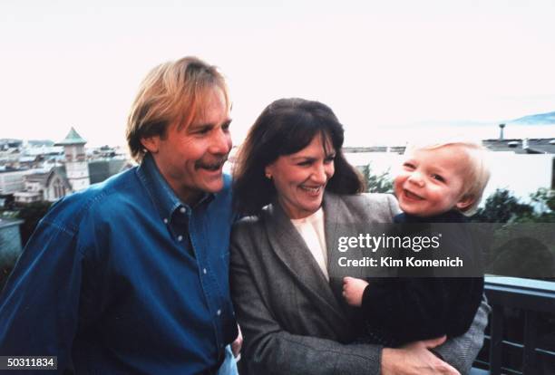 Author Dr. Nancy Snyderman & TV producer husband Doug Meyers posing w. Son Charlie outside home.