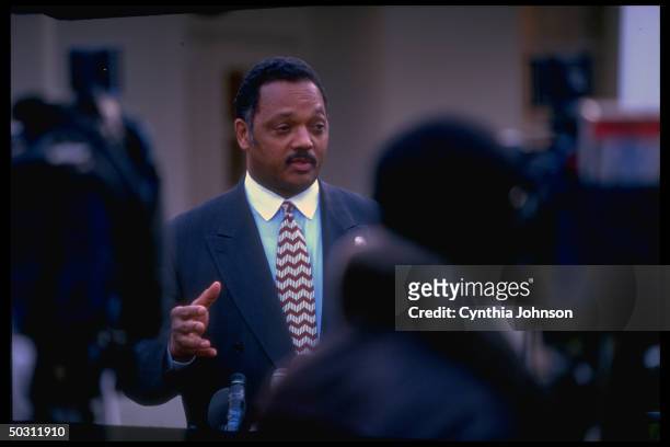 African-American leader Rev Jesse Jackson pausing in White House driveway to speak with press after meeting with Clinton aide Sandy Berger.