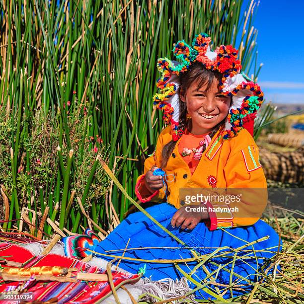 little girl on uros floating island selling souvenirs, lake tititcaca - uroseilanden stockfoto's en -beelden