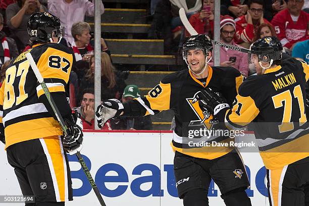 Kris Letang of the Pittsburgh Penguins celebrates his power play goal with teammates Sidney Crosby and Evgeni Malkin in the second period of an NHL...