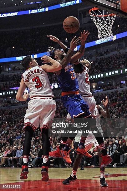Derrick Williams of the New York Knicks looses control of the ball as he tries to shoot between Doug McDermott and Taj Gibson of the Chicago Bulls at...