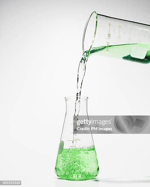 beaker pouring green liquid into laboratory flask - beaker 個照片及圖片檔