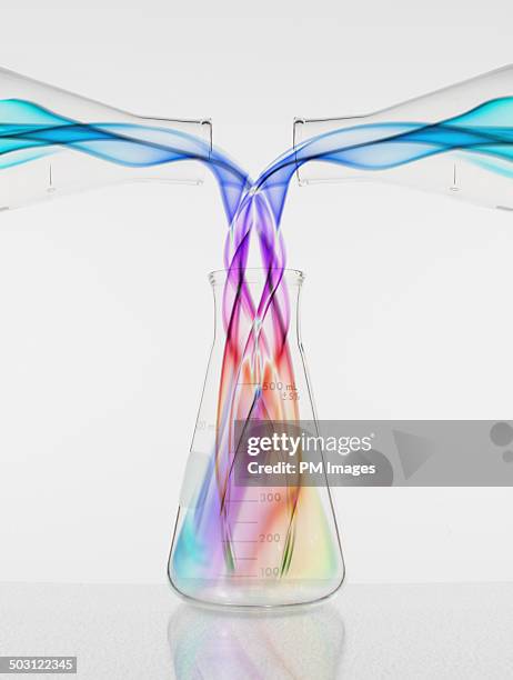 colors pouring into beaker - mengen stockfoto's en -beelden