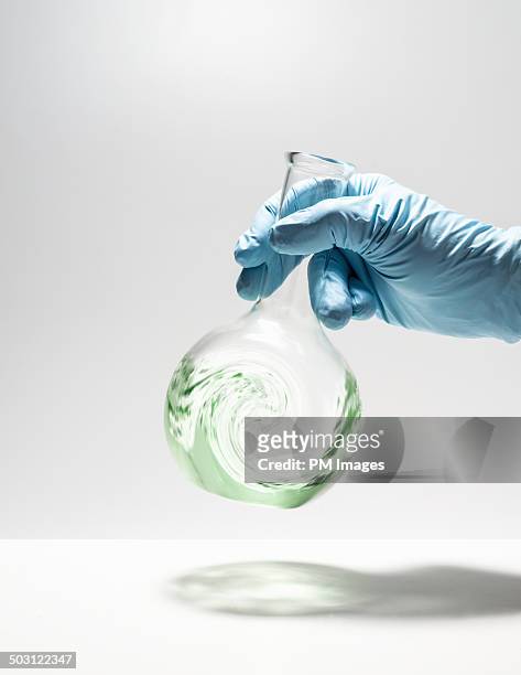 swirling liquid inside beaker - pallone di vetro foto e immagini stock