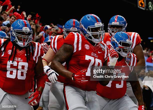 Laremy Tunsil of the Mississippi Rebels celebrate his touchdown with teammates during the second quarter against the Oklahoma State Cowboys in the...