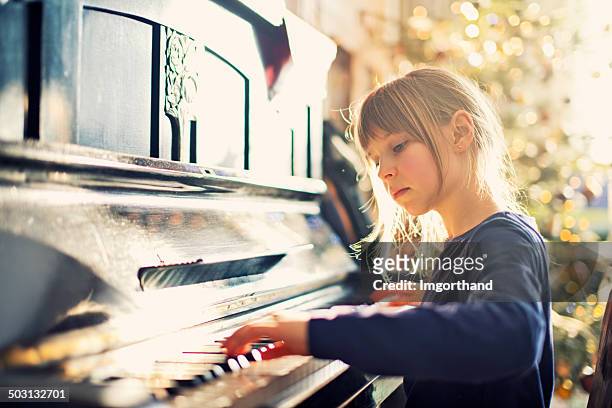 beautiful little girl playing on grandmother piano - pianist stock pictures, royalty-free photos & images
