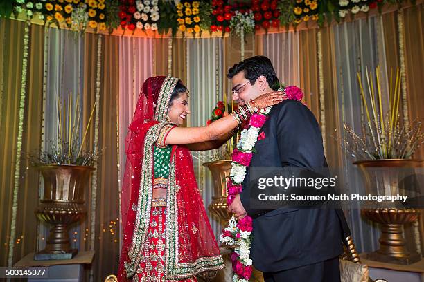 couple performing jaimala during their wedding. - indian bride closeup stock-fotos und bilder