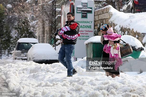 Family goes across the street at Bhamdoun town after snowfall in Beirut, Lebanon on January 2, 2016.