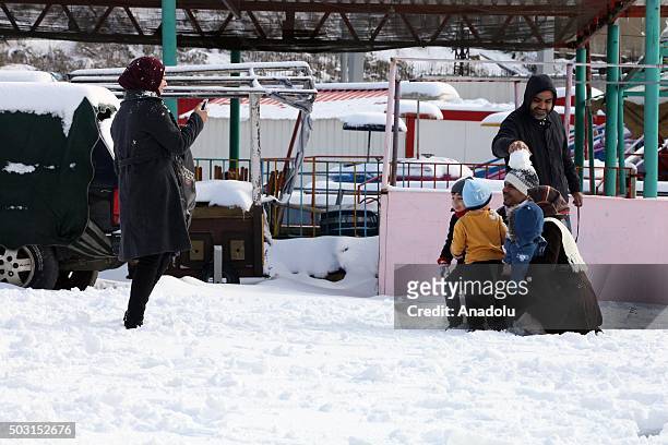 People pose for pictures on snow at Bhamdoun town in Beirut, Lebanon on January 2, 2016.