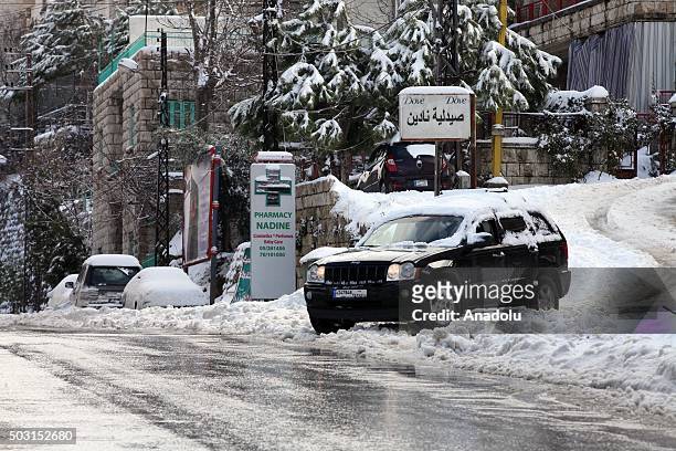 Cars covered in snow pass through a street at Bhamdoun town in Beirut, Lebanon on January 2, 2016.