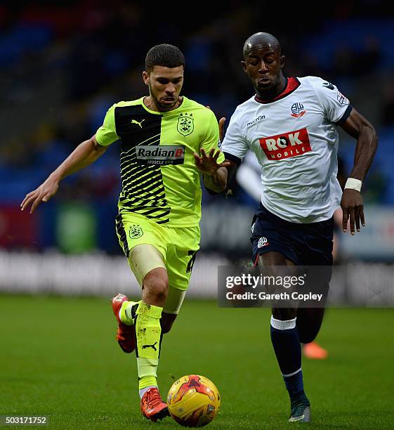 Nahki Wells of Huddersfield Town is tackled by Prince-Desir Gouano of Bolton during the Sky Bet Championship match between Bolton Wanderers and...