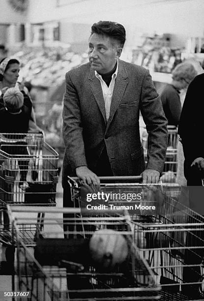 Author Peter De Vries pushing a shopping cart through the aisles of the local supermarket.