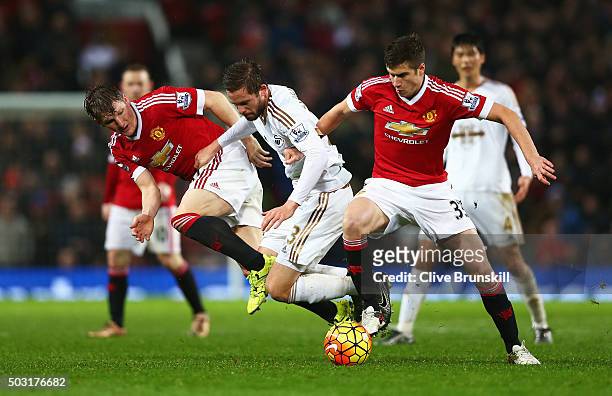 Gylfi Sigurdsson of Swansea City competes for the ball against Bastian Schweinsteiger and Paddy McNair of Manchester United during the Barclays...