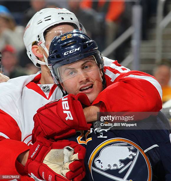 Johan Larsson of the Buffalo Sabres is grabbed by Joakim Andersson of the Detroit Red Wings during an NHL game on January 2, 2016 at the First...