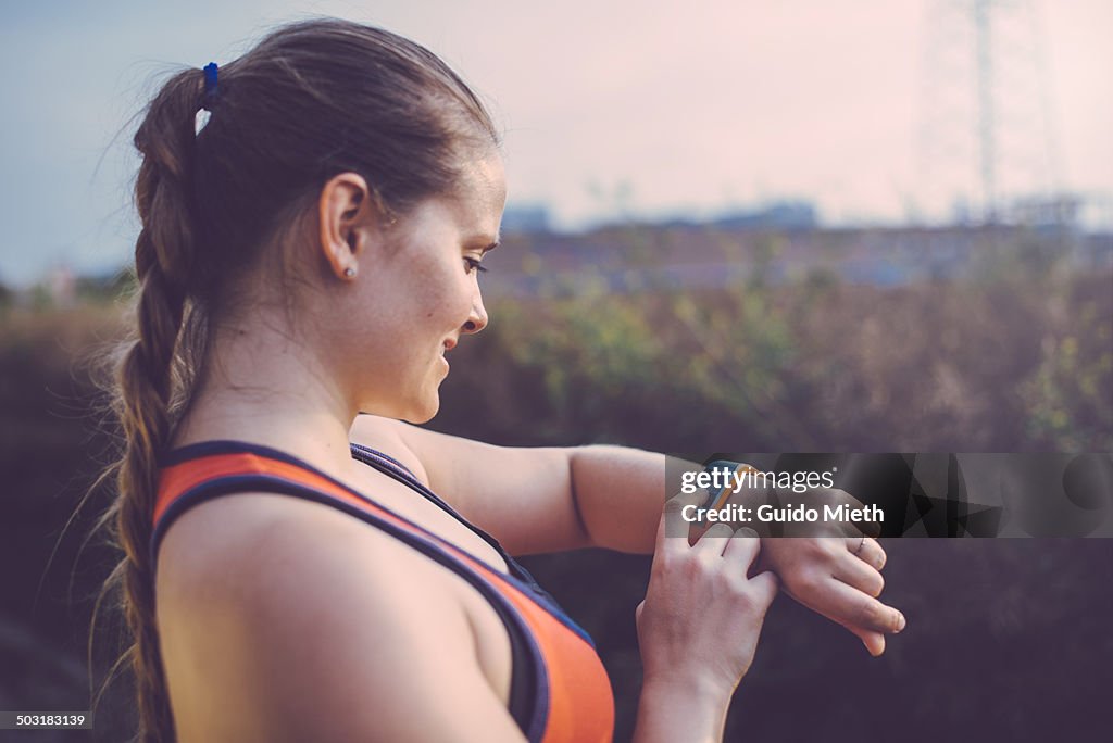Woman using smartwatch outdoor.