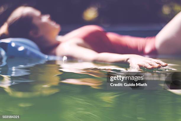 woman relaxing in pool. - pool raft stock pictures, royalty-free photos & images