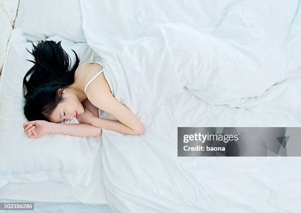 hermosa joven mujer asiática dormitorio - acostado de lado fotografías e imágenes de stock